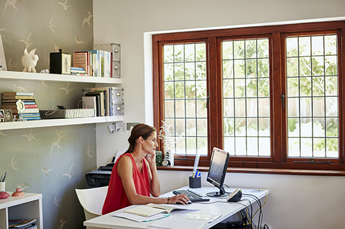 Woman using computer and phone at desk