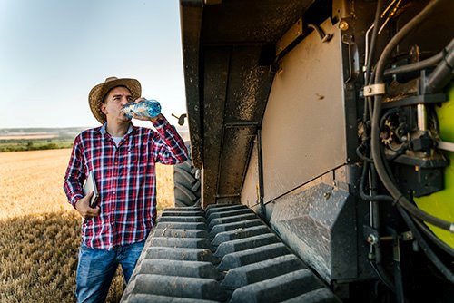 Farmer rests and drinks water