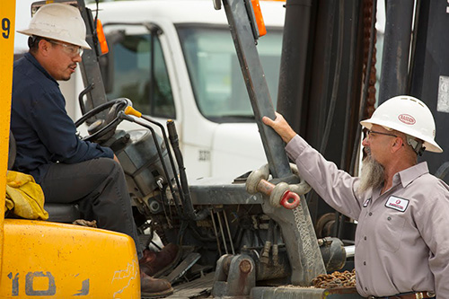 Two employees speaking to one another at work.